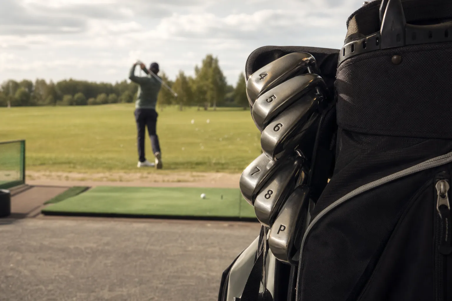 Ett järnset lutat mot en golfbag med klubbnumren synliga på sulorna