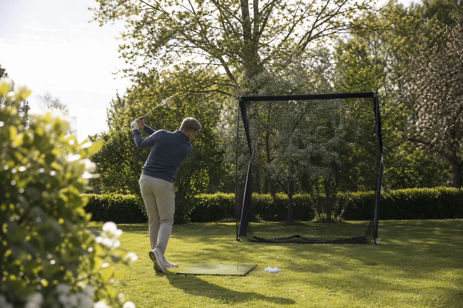 Golfträningsnät uppställt i en trädgård med fri yta runt omkring