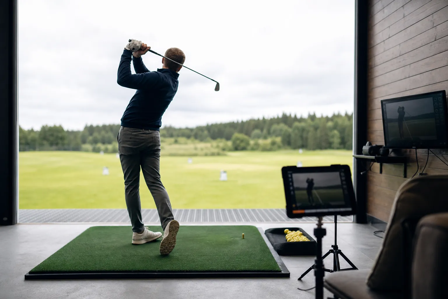 Golfare provslår med en klubba medan mätutrustning registrerar svingen under en fitting